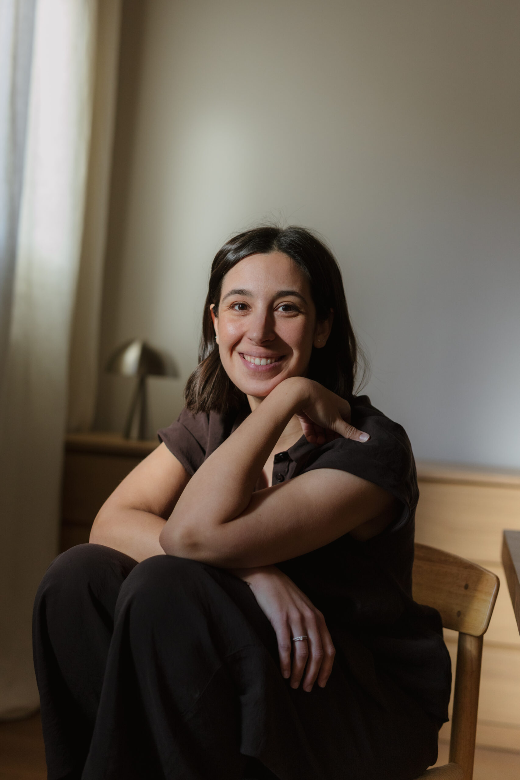 Núria sonriendo, sentada en una silla de su espacio de trabajo